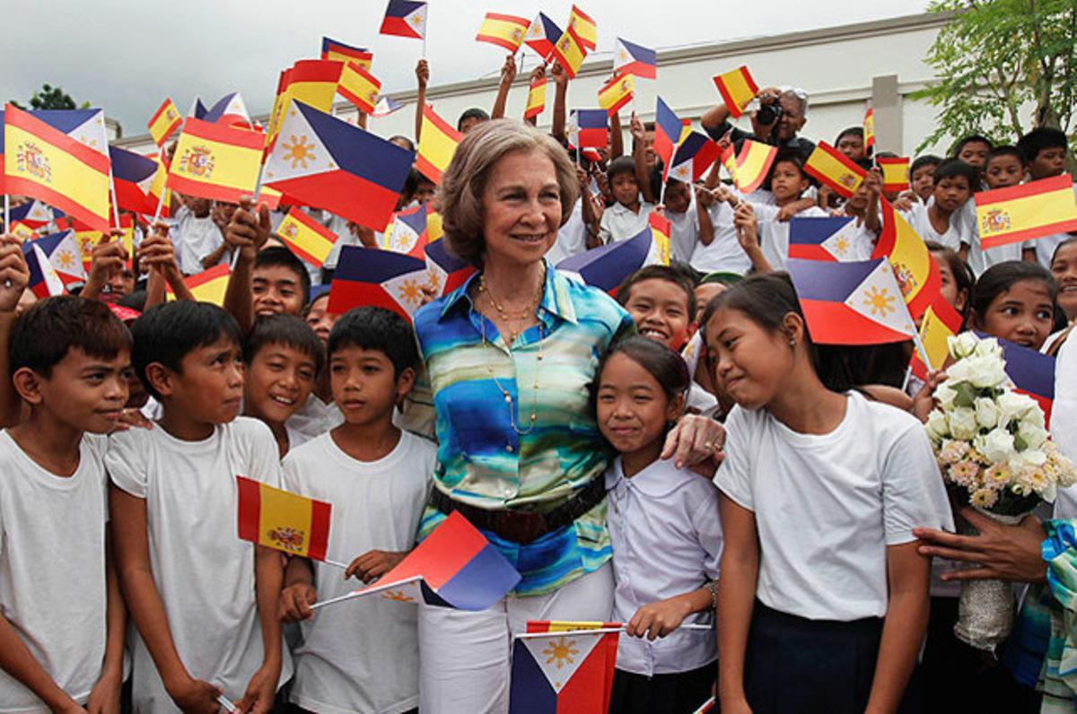 La Reina Sofia, envoltada de nens, a l’arribar al Centre d’Evacuació de Camalig, un refugi per a desastres naturals, durant la seva visita a Legaspi (Filipines).