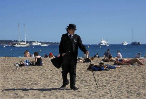 A man dressed as Charlie Chaplin walks on the beach during the 67th Cannes Film Festival in Cannes