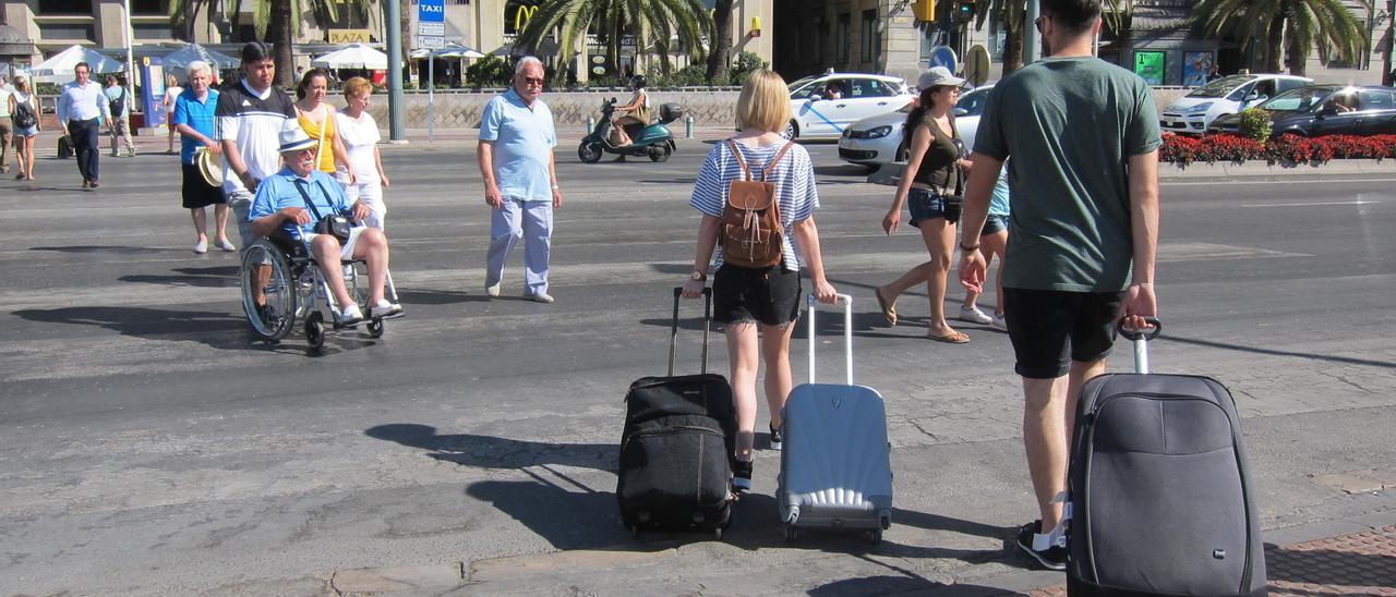 Turistas llegan a Málaga con sus maletas.