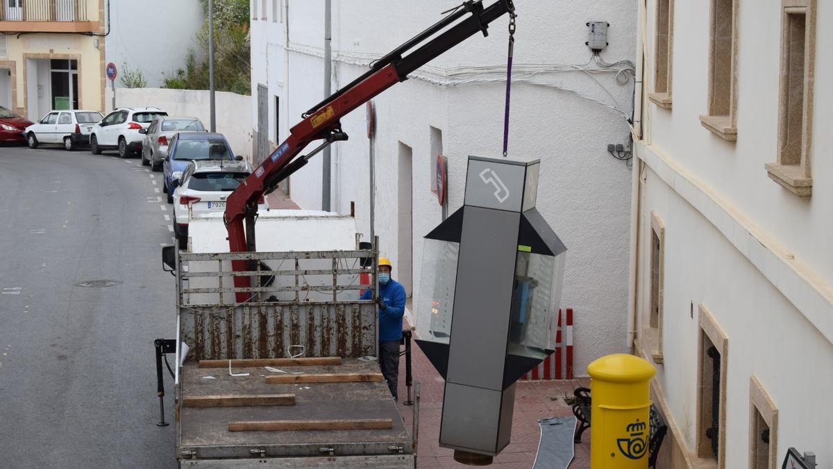 Una grúa retira una de las cabinas de teléfono