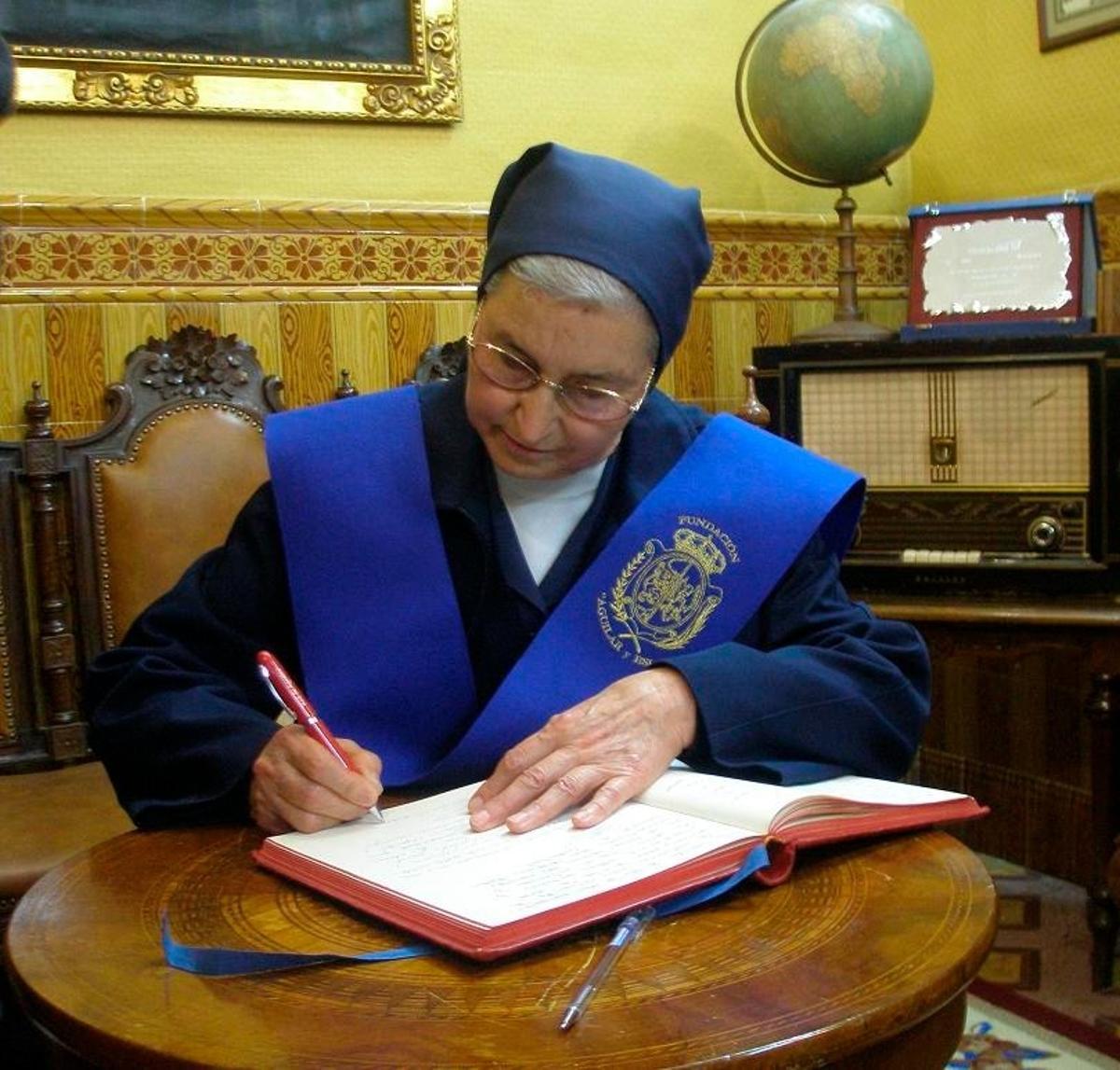 Sor Pilar Pedrosa firma en el libro de honor del IES Aguilar y Eslava en 2009.
