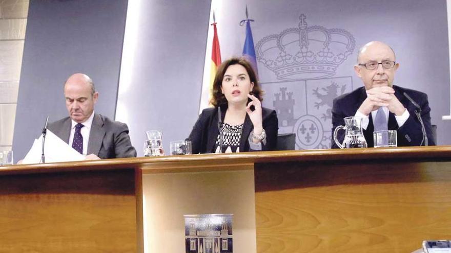 Luis de Guindos, Soraya Sáenz de Santamaría y Cristóbal Montoro, ayer.