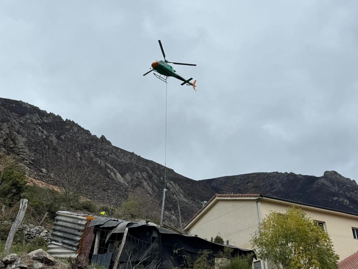 El helicóptero sobre las casas colocando un tensor.