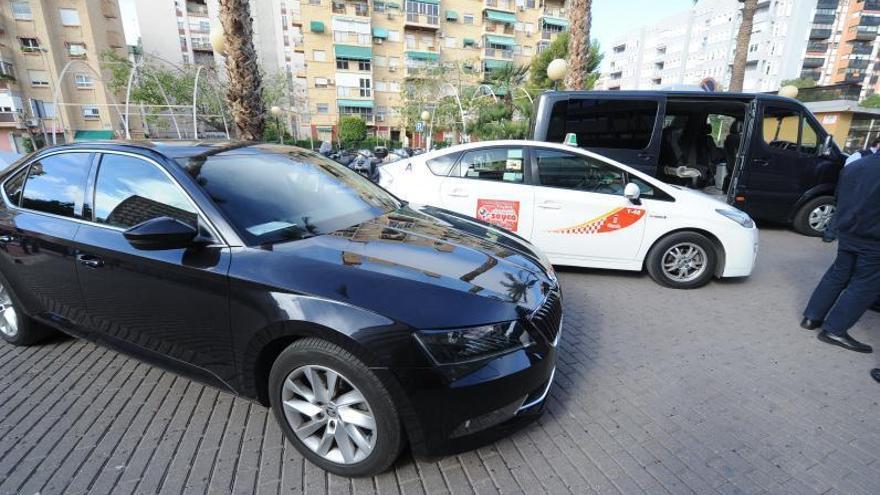 Vehículos de VTC junto a un taxi en la ciudad de Murcia.