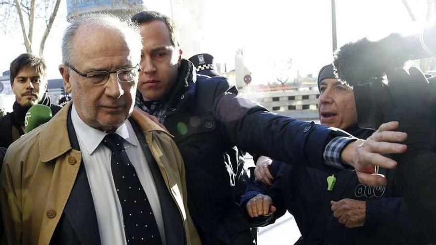Rato, rodeado por guardaespaldas y policías, a su salida, ayer, del juzgado, en Madrid.