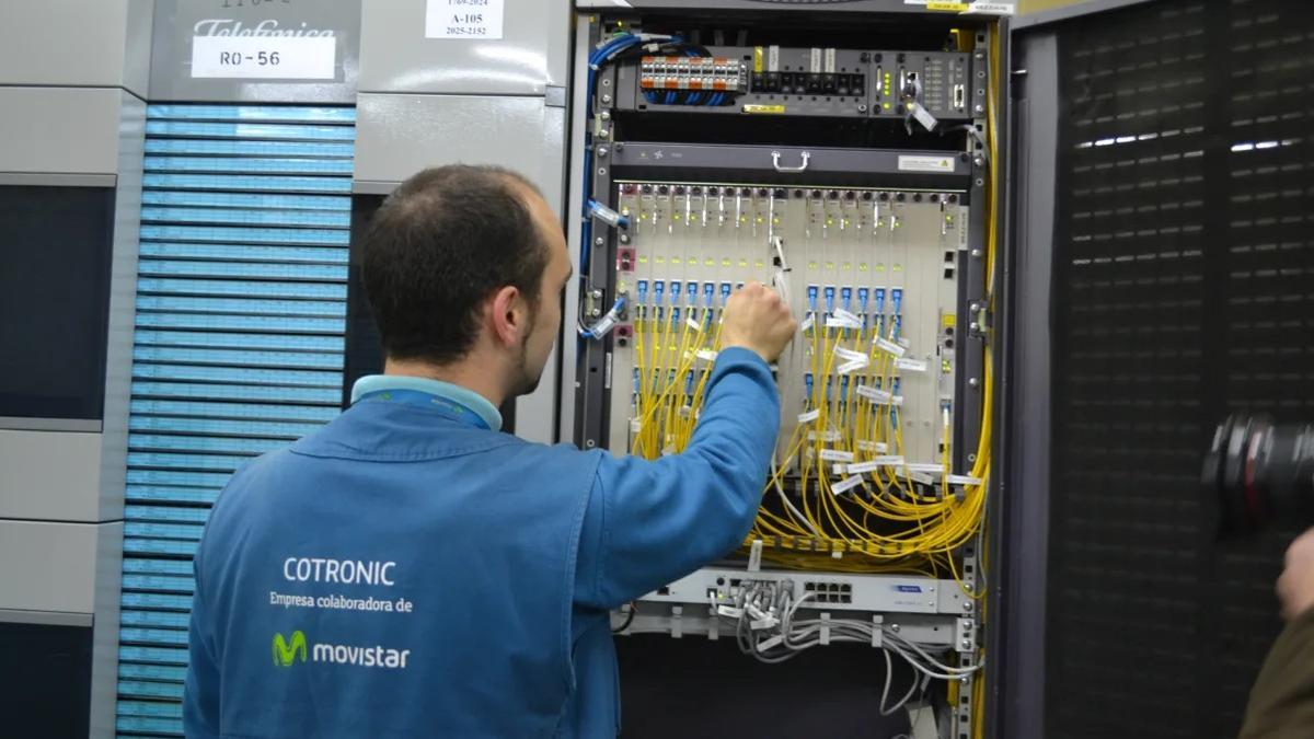 Un operario de una subcontrata de Telefónica examina un cuadro con fibra óptica