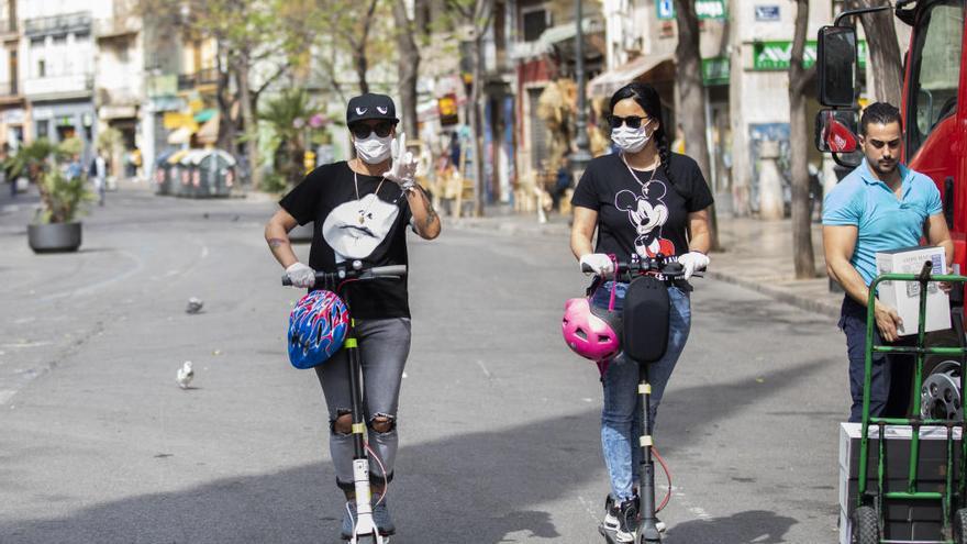 Dos jóvenes con mascarillas por el centro de València.