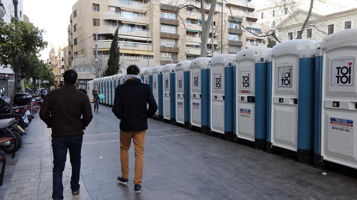 Dos hombres pasan por delante de los urinarios colocados en el Lluís Vives de València.