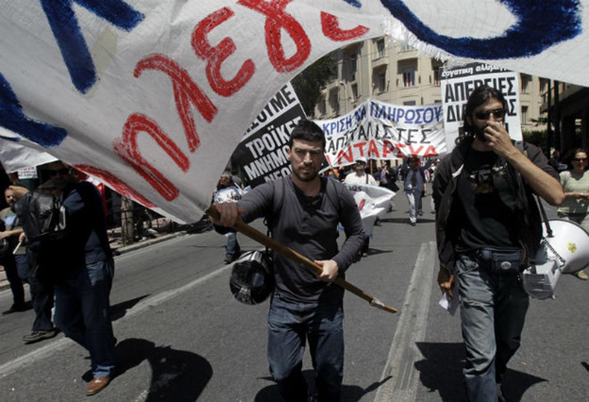 Uns treballadors en atur participen en una manifestació a Atenes del Primer de Maig.