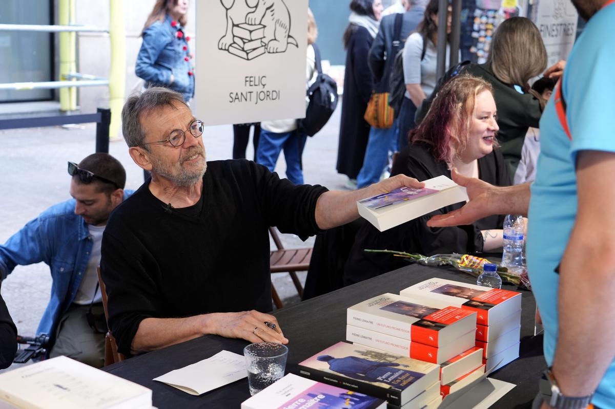 L'escriptor Pierre Lemaitre signant llibres a la parada de Finestres davant de la llibreria a Barcelona