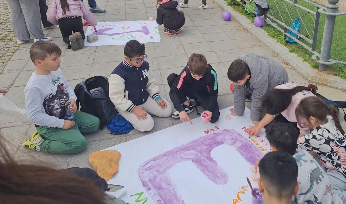 FOTOS | Alumnos de los colegios Cerro de Reyes y Pastor Sito pintan de violeta el barrio por el 8M