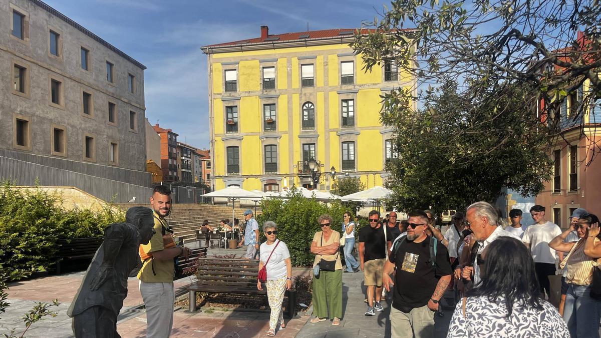 Turistas ante la estatua de Rambal, en Cimavilla.