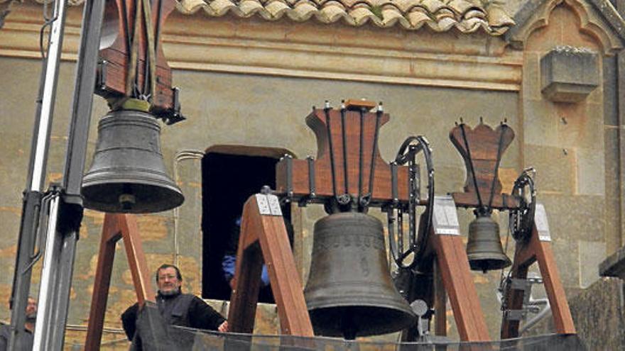 Varios trabajadores preparan la campana.