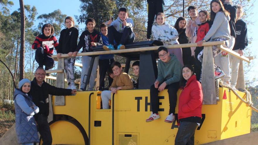 El alcalde de Nigrán con estudiantes del colegio Carlos Casares posando en una apisonadora restaurada para el centro.
