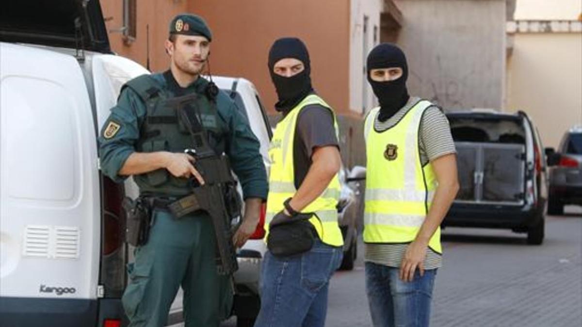 TRABAJO MANO A MANO 3 Dos agentes de la Guardia Civil (izquierda) y uno de los Mossos (derecha) trabajan conjuntamente en la operación en Vinaròs (Castellón).