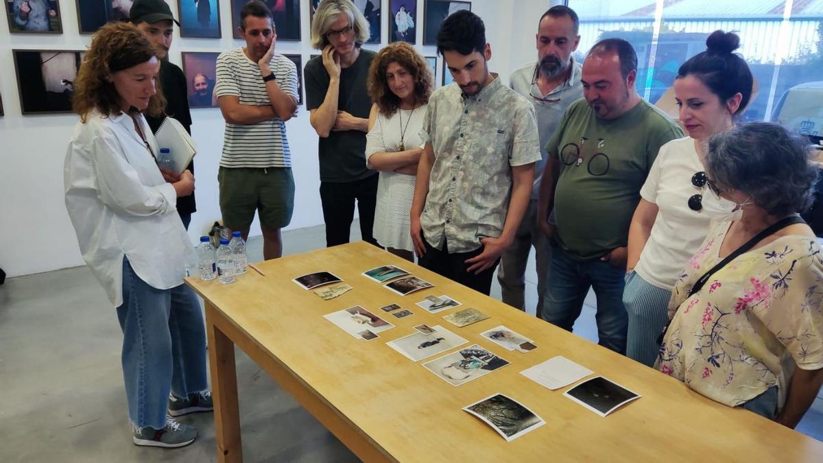 Scarlat y los asistentes al taller del sábado examinando fotografías.   | //TONO ARIAS