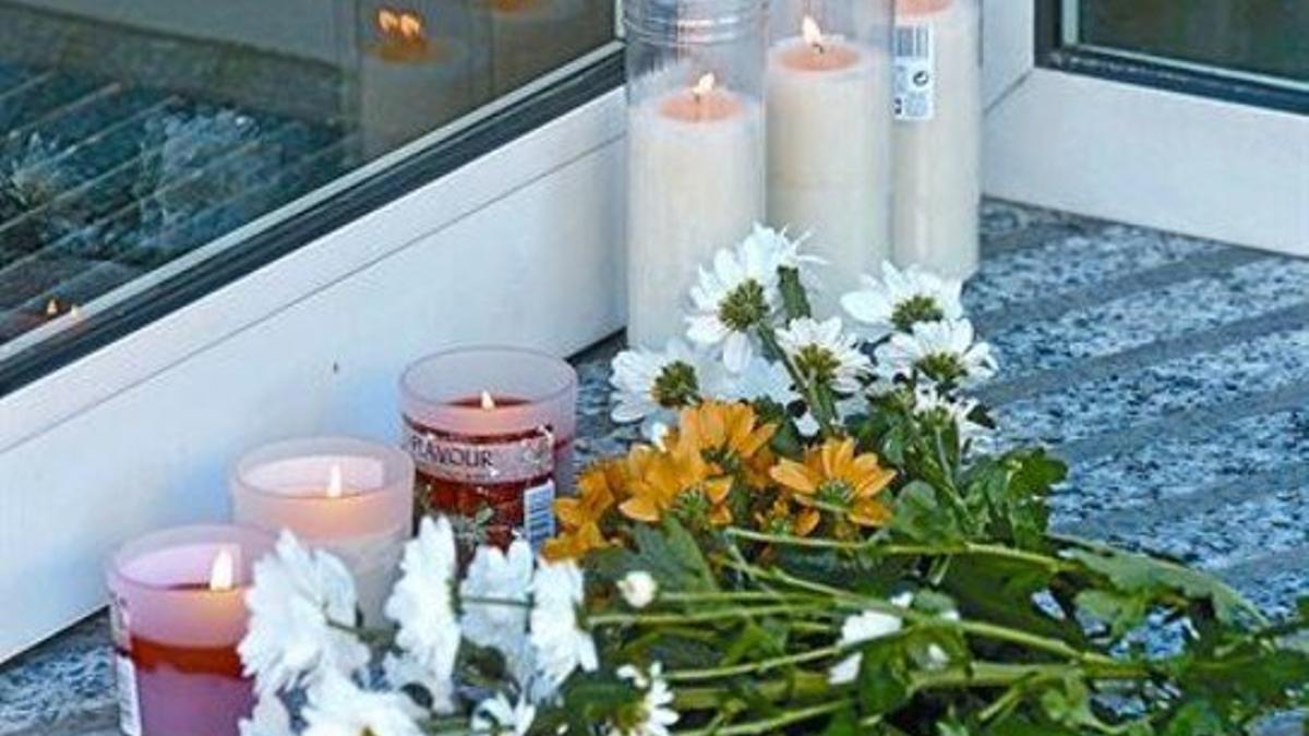 Altar 8 Flores y velas ante la sucursal de la CAM de Olot, donde ayer fueron asesinados dos empleados.