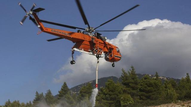 Un helicòpter d’extinció d’incendis omple el dipòsit d’aigua durant un incendi forestal als voltants de Mègara, a l’Àtica.
