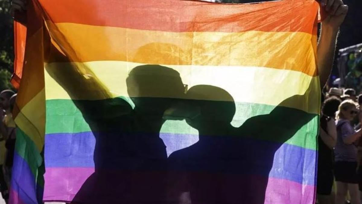 Dos joves amb una bandera LGTBI a Barcelona