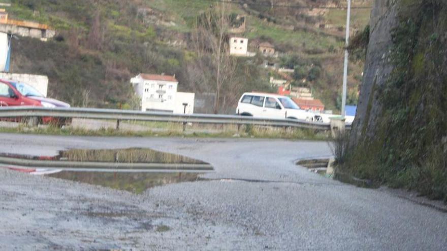 La carretera Moreda-Boo, llena de baches y socavones