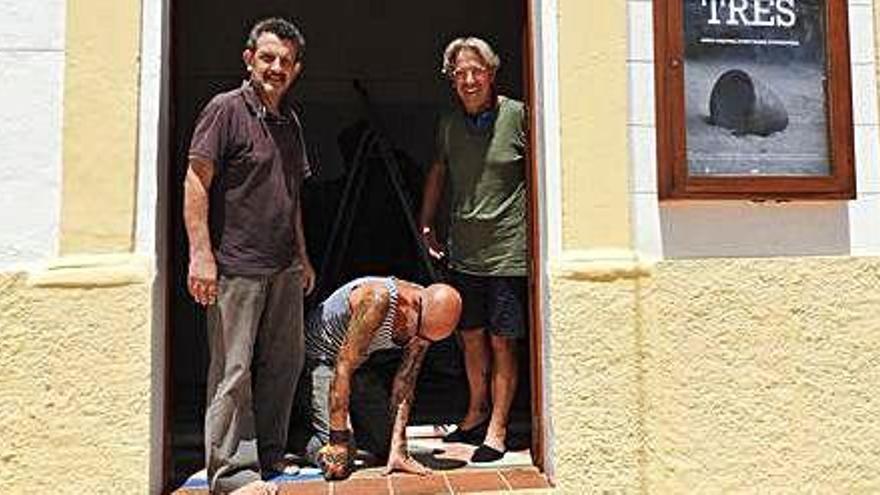 Jordi Sarrà, Manolo Oya (agachado) y Enric Majoral en la puerta de la sala de exposiciones.