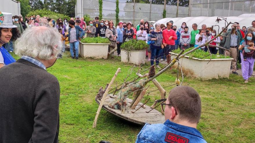 Herminio, de espaldas, ante la escultura que realizó con residuos y restos orgánicos. | T. Cascudo