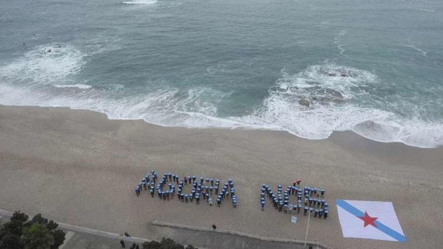 La candidatura de NÓS formó un mosaico junto a la bandera gallega en la playa de Riazor. // FdV