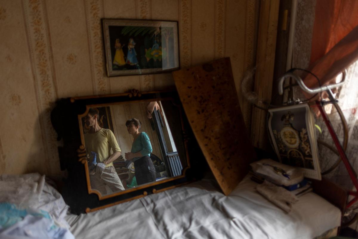 Olena y su esposo Sergiy se reflejan en un espejo en su apartamento dañado por los bombardeos rusos, mientras continúa el ataque de Rusia contra Ucrania, en Kharkiv, Ucrania.
