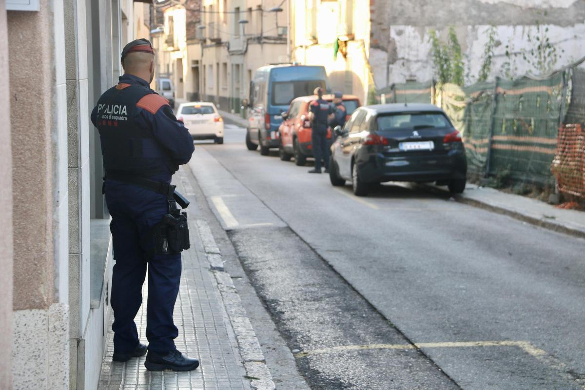Un agente de los Mossos frente a uno de los inmuebles registrados en Sentmenat.