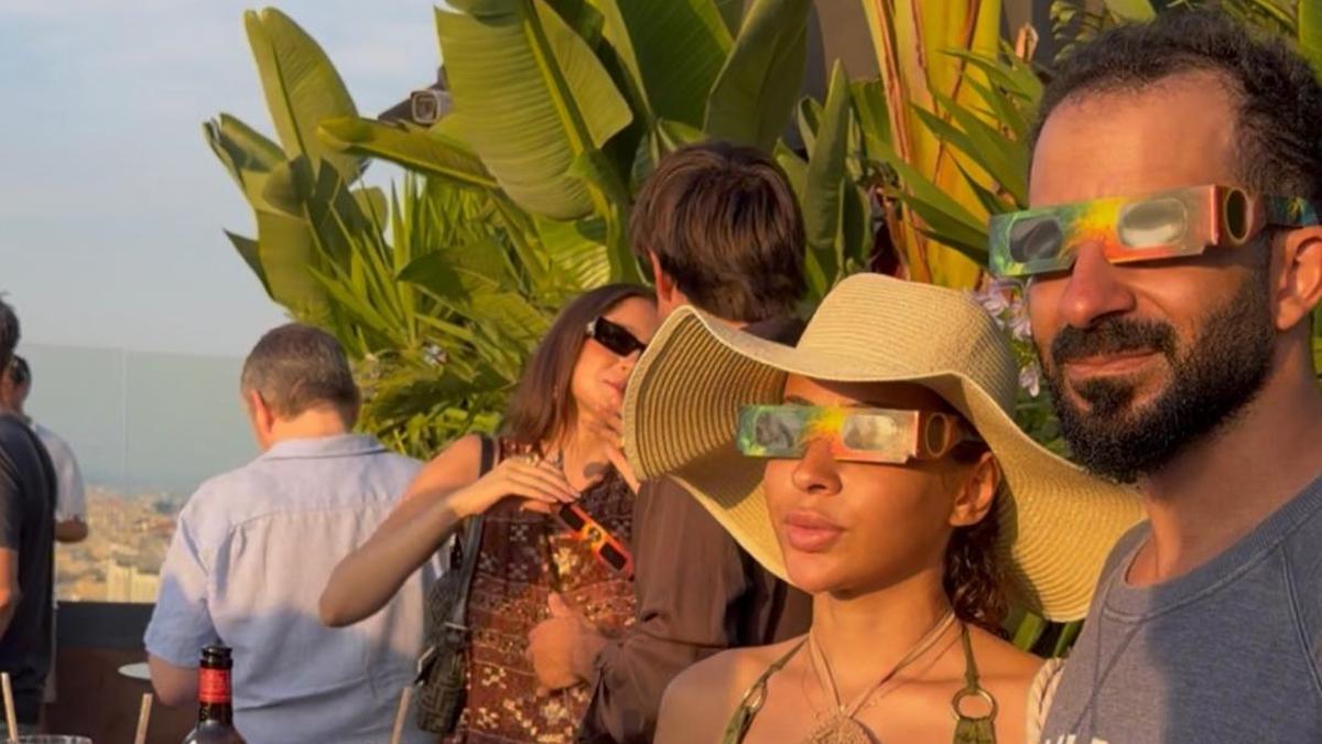 Dos clientes de la terraza del Nobu miran el eclipse.