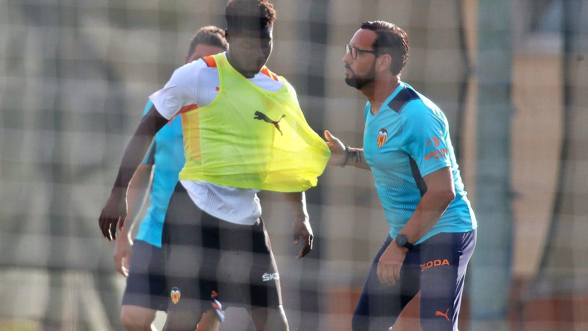 Bordalás coje a Yunus Musah durante el entrenamiento de ayer en el Resort Oliva Nova Golf, donde el Valencia CF está hospedado.  | F. CALABUIG