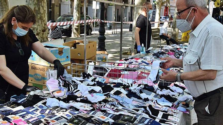 Un client comprant en una parada de roba del mercat setmanal del Vall de Berga, que ahir va omplir de vida i animació la ciutat