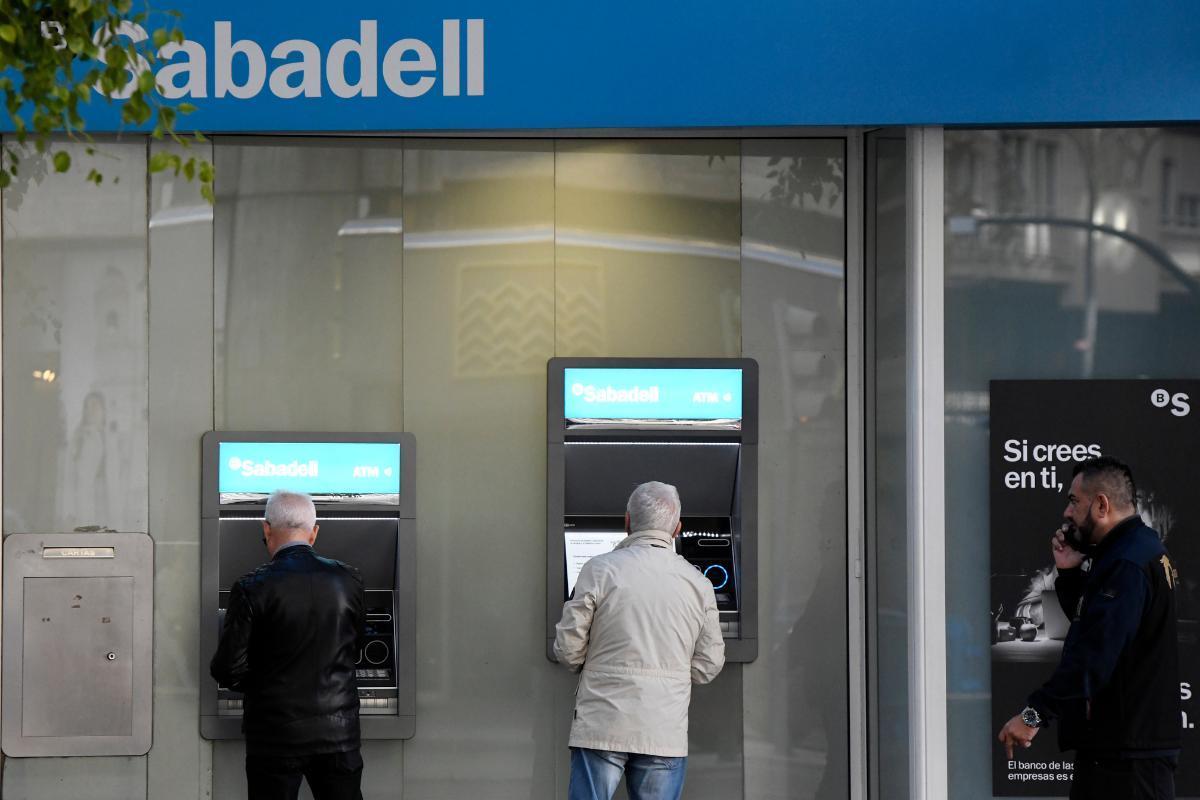 Dos personas acuden al cajero a sacar dinero.