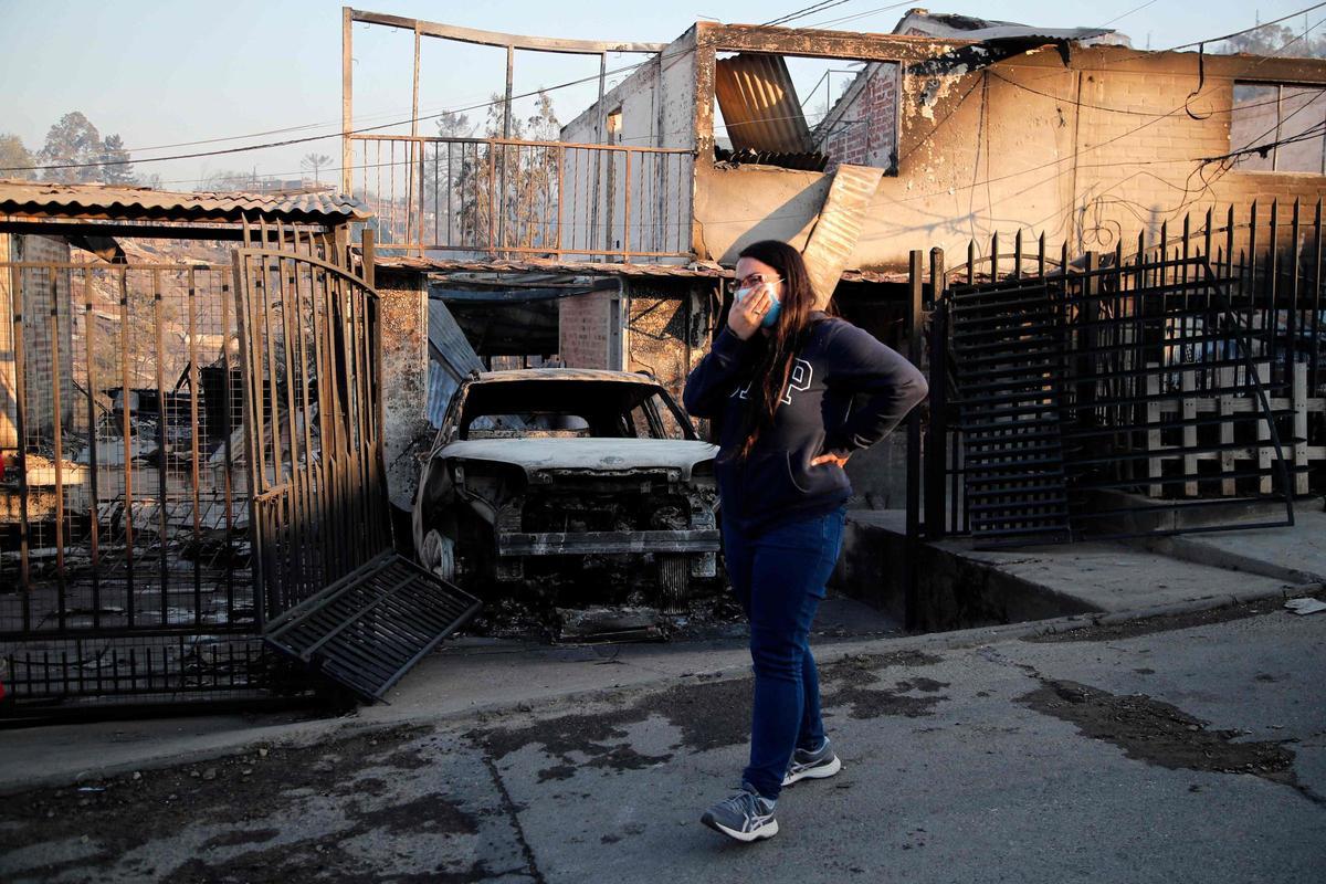 Una mujer llora mientras mira casas quemadas luego de un incendio que afectó los cerros de Viña del Mar, Chile, el 3 de febrero de 2024. La región de Valparaoso y Viña del Mar, en el centro de Chile, amaneció el sábado con un toque de queda parcial para permitir el movimiento de evacuados y el traslado de equipos de emergencia en medio de una serie de incendios sin precedentes, informaron las autoridades.