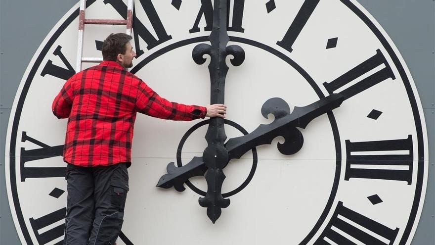 Un operario cambia las manecillas del reloj de una iglesia de Dresde, en Alemania.