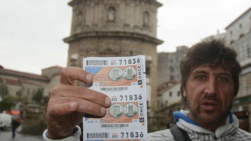 Fernando Golán muestra en la plaza de A Peregrina los cupones dedicados a Pontevedra. // Rafa Vázquez