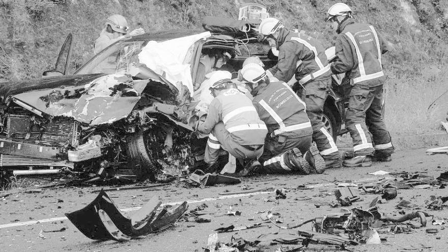 Bomberos y sanitarios atienden al ocupante de uno de los vehículos. En el recuadro, Manuel Soage. // S.A.