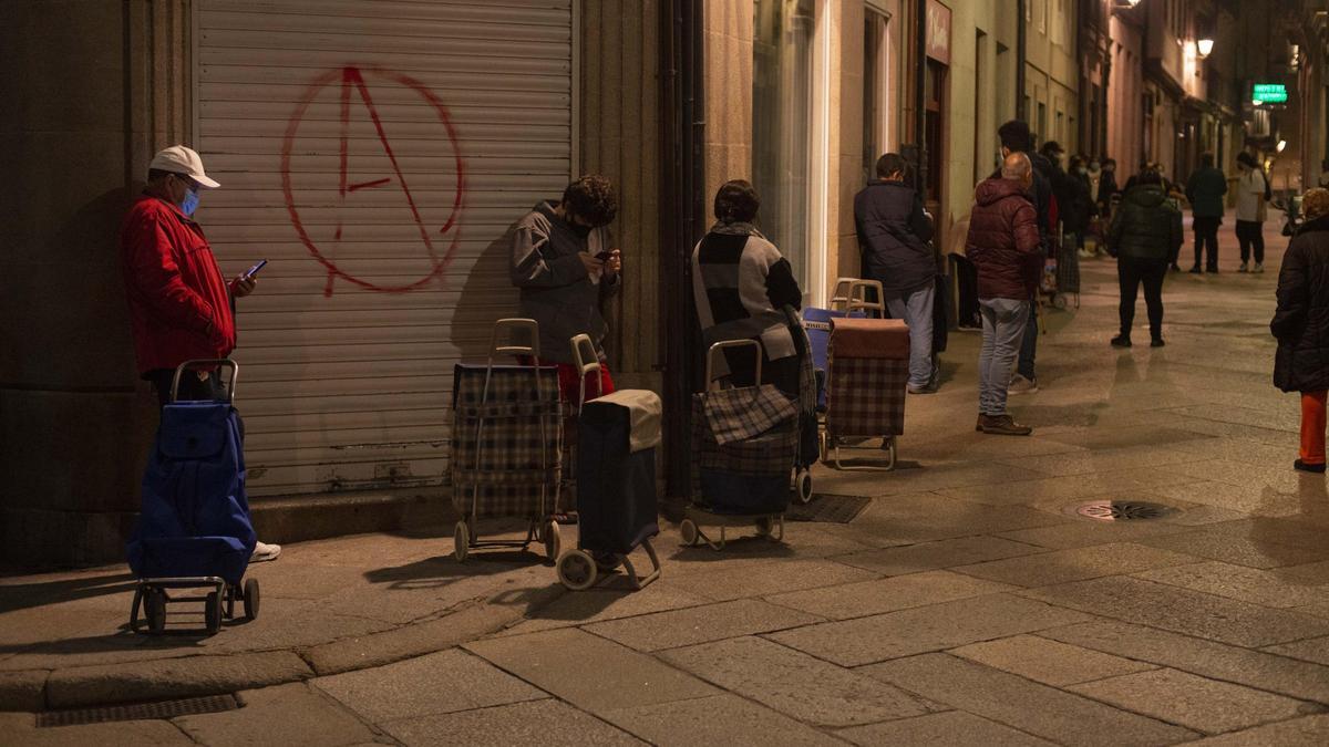 Una cola para recoger alimentos, en la parroquia ourensana de Santa Eufemia, el pasado noviembre. // BRAIS LORENZO