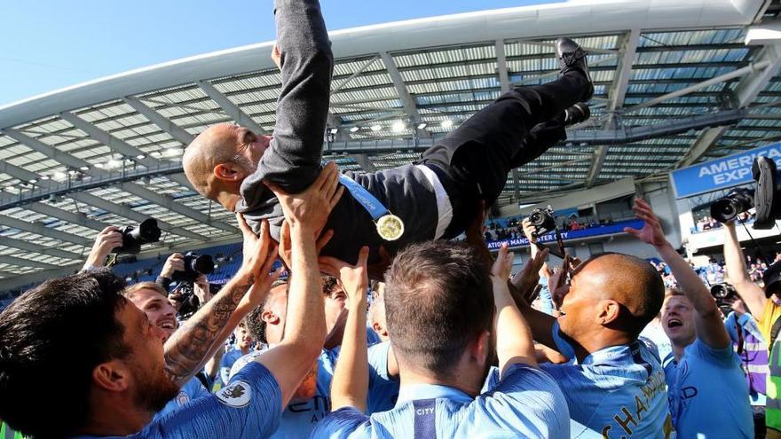 Los jugadores del City mantean a Guardiola en la celebración de un título anterior