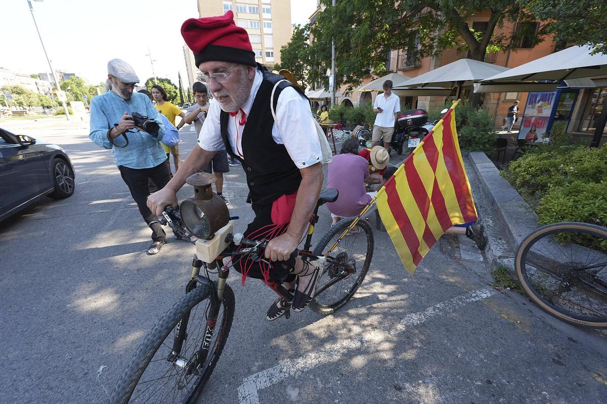 Un voluntari porta la Flama del Canigó en bicicleta.