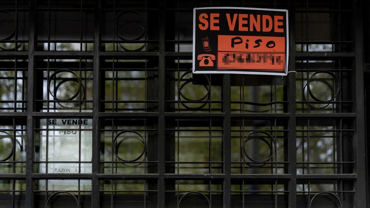 Vista de un cartel de 'Se vende' piso en un portal