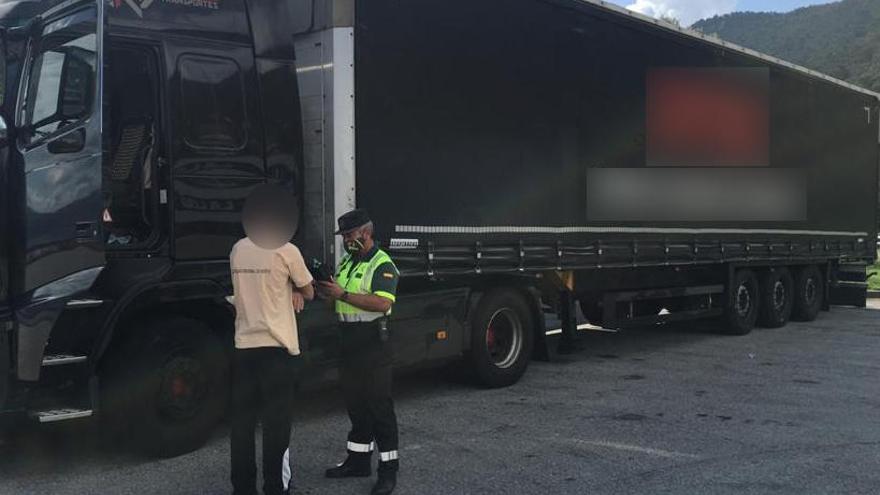 Un agente de la Guardia Civil practicándole la prueba de alcoholemia al camionero. // G. C.