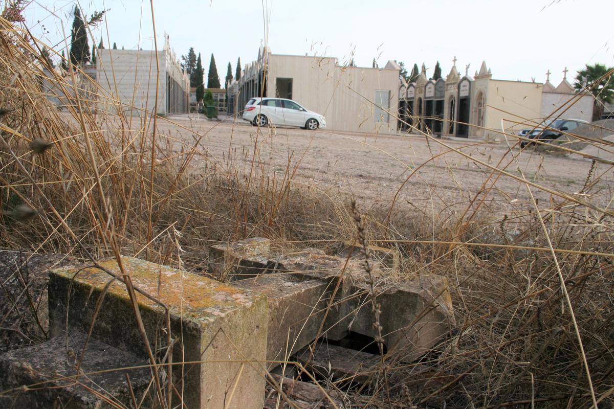 Una cruz de piedra, entre la maleza, en la zona donde se construyen nuevas capillas.