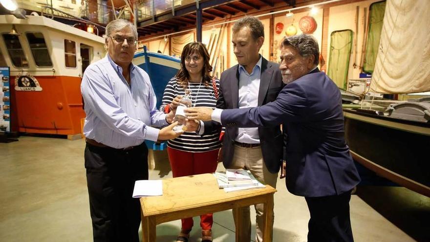 Rafael Lobeto, Amelia Fernández, Jorge Suárez y Manuel González, ayer, en el Museo Marítimo de Asturias, con una botella con agua del mar Cantábrico.