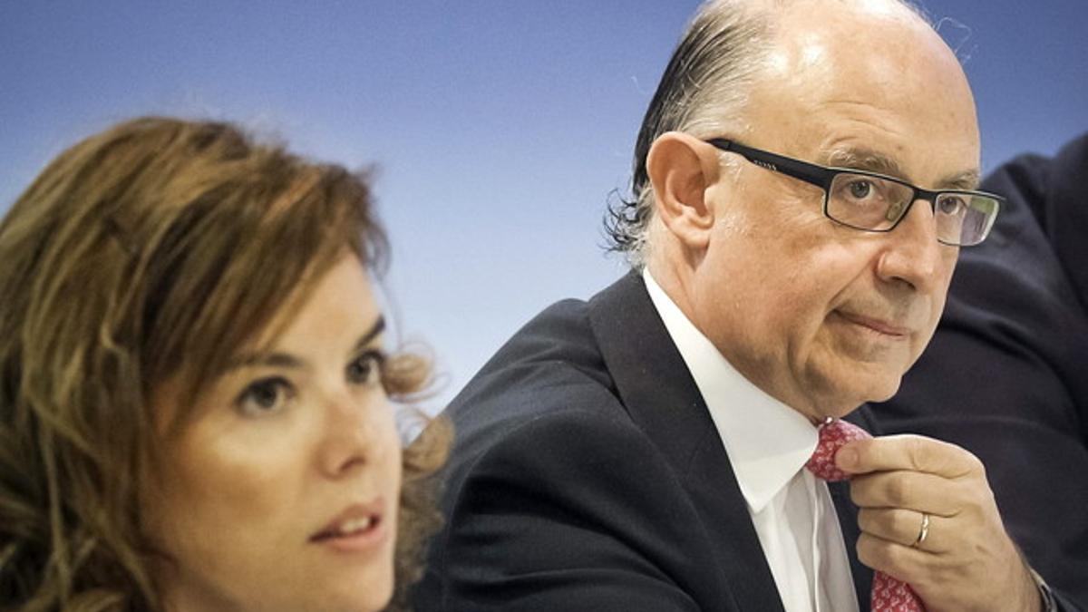 La vicepresidenta del Gobierno, Soraya Sáenz de Santamaría, y el ministro de Hacienda, Cristóbal Montoro, posan para la prensa esta mañana, en el palacio de La Moncloa.