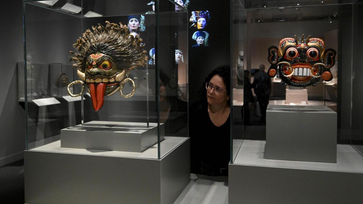 Una visitant contempla dues màscares exposades al CaixaForum