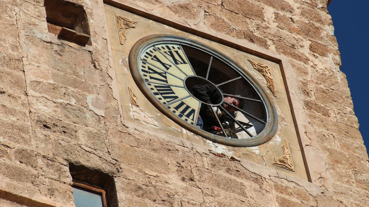 Momento en el que un operario sustituye la esfera del reloj del campanario de Segorbe.