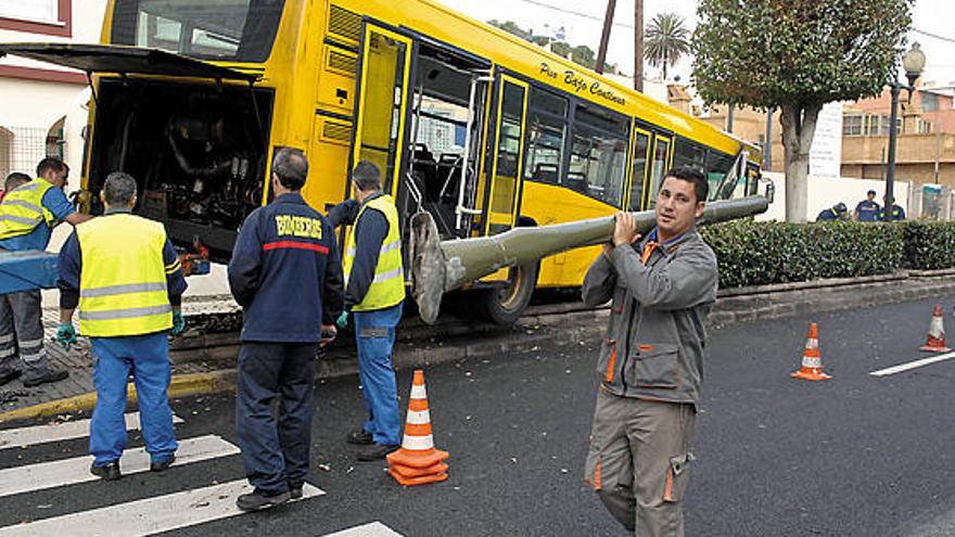 Un operario retira el semáforo arrollado por la guagua que se estrelló contra una escuela infantil, ayer.  ANDRÉS CRUZ