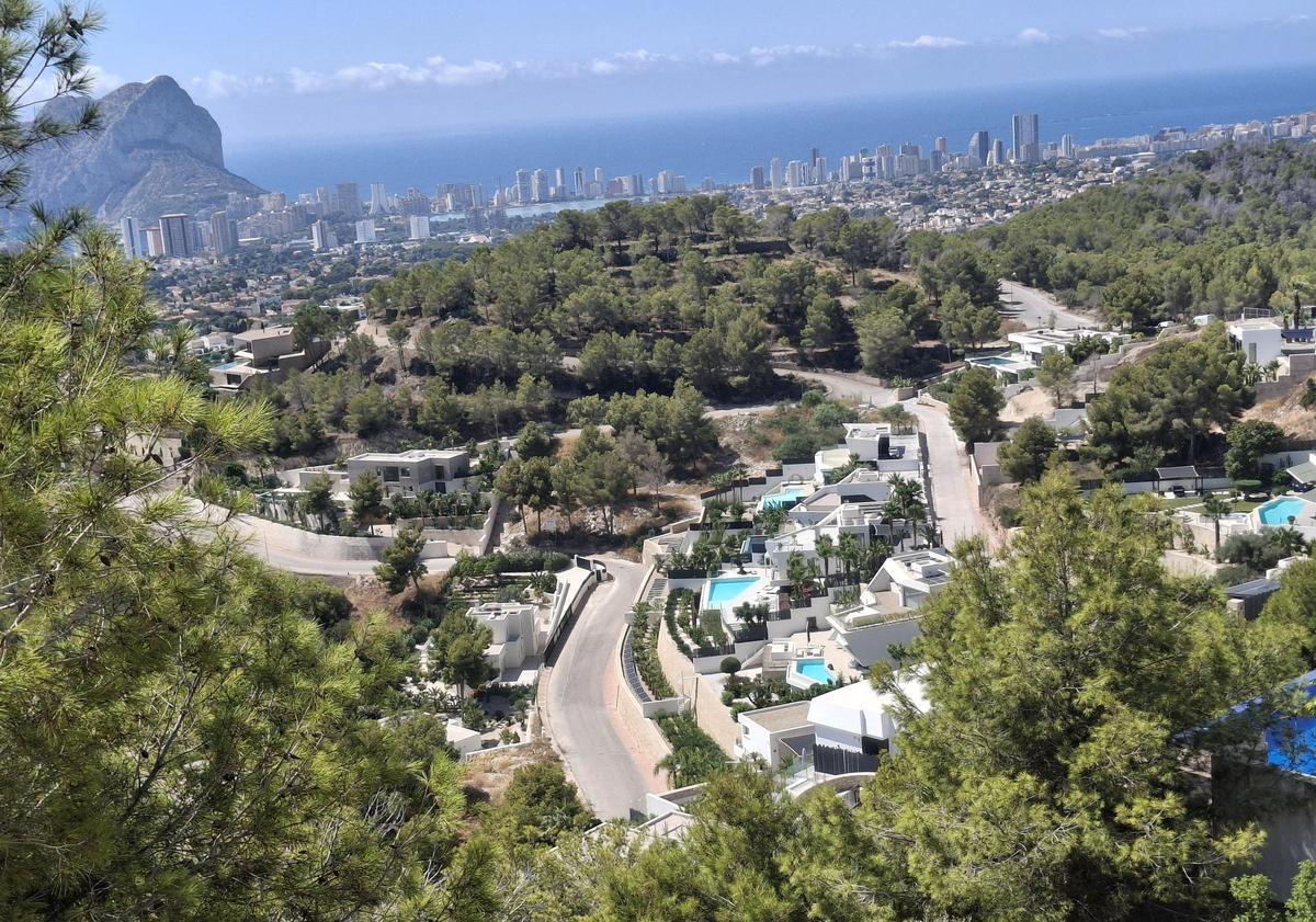 Chalés de modernísima arquitectura con piscina y, al fondo, las torres de apartamentos de Calp