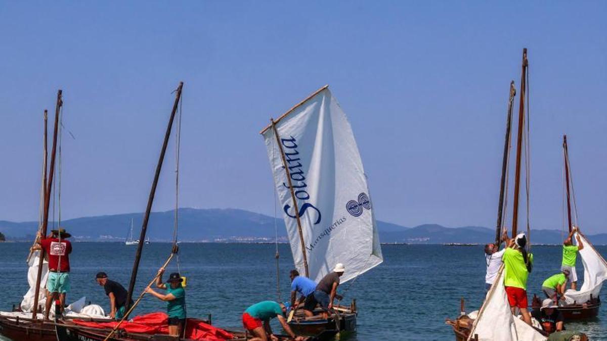 Varios tripulantes tratan de aparellar canto antes as dornas na regata do Bao.
